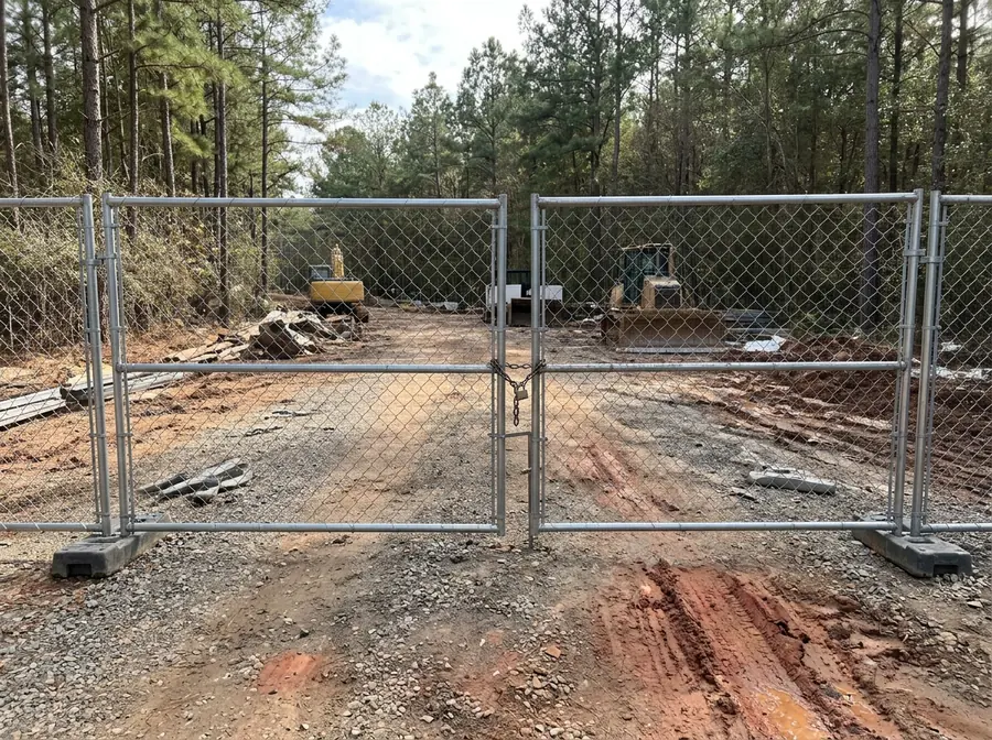 Temporary chain link swing gate with a chain and padlock at a construction site entrance